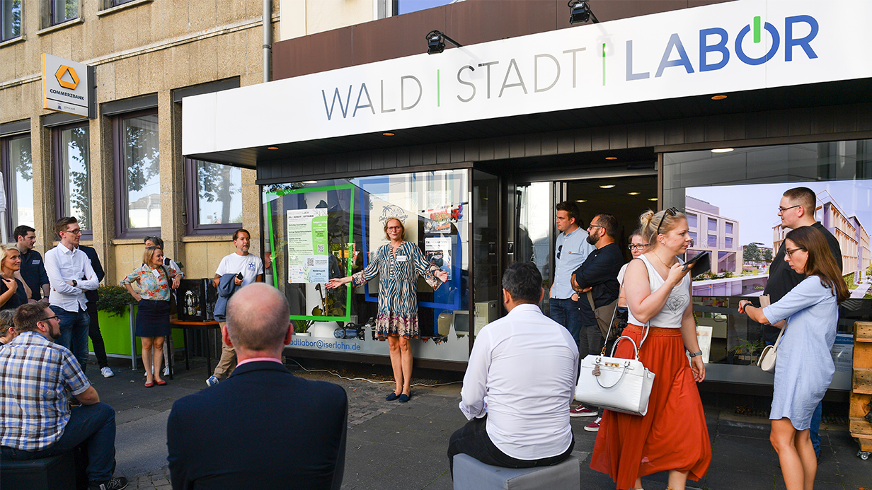 Einige Menschen stehen vor dem WALD | STADT | LABOR, einem Gebäude, in Iserlohn.