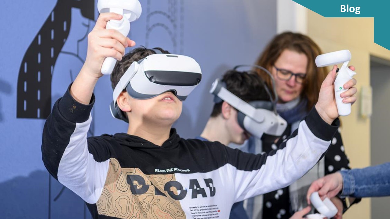 Ein Junge mit VR-Brille und Joysticks bewegt sich in einem Raum. Im Hintergrund sind eine Frau und ein weiterer Junge zu sehen.